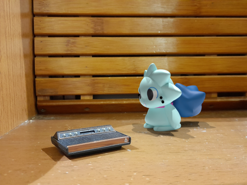 Mint is staring at a miniature Atari 2600. For mintpaws